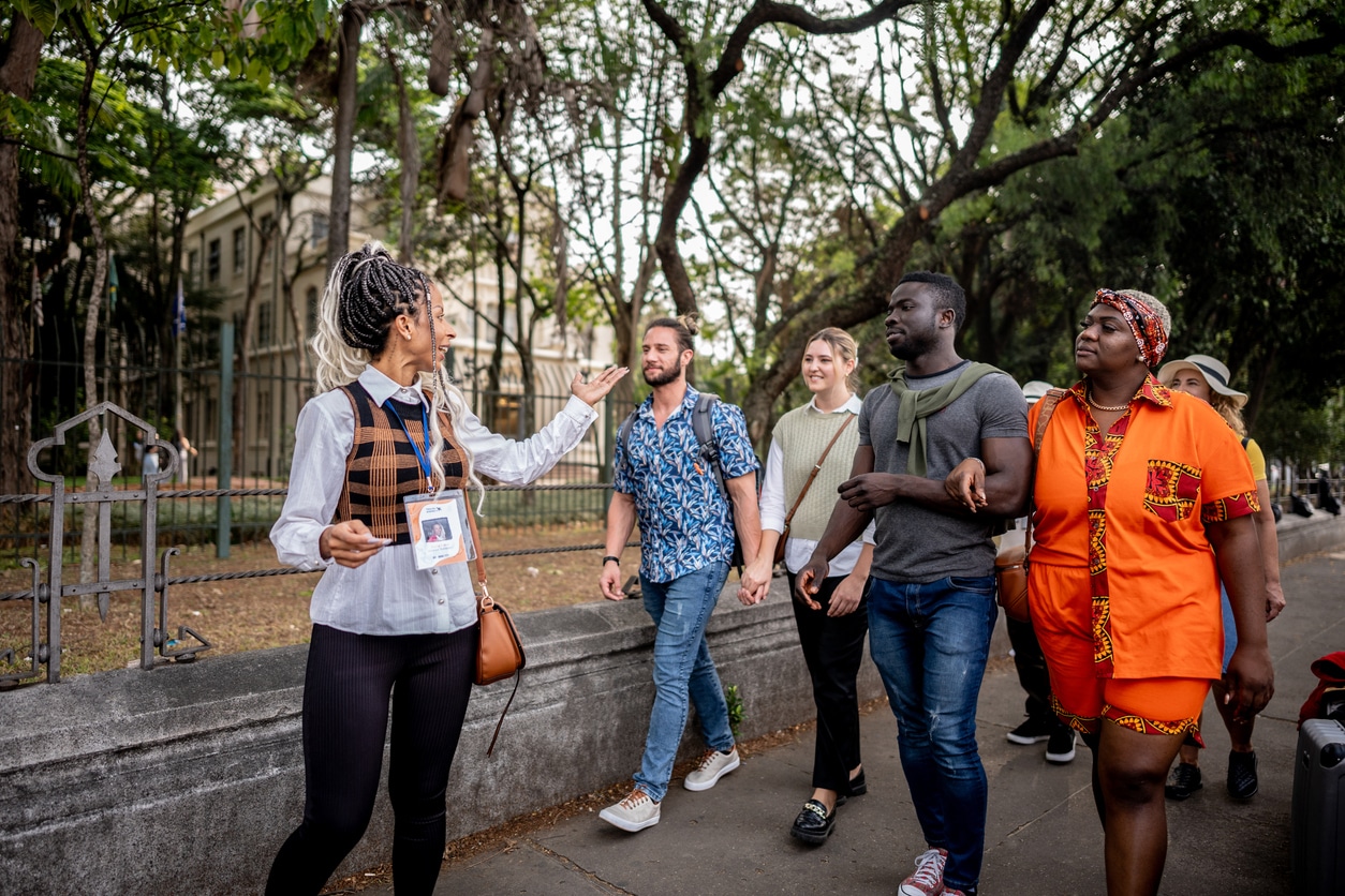 Tour guide walking while explaining to tourists in the street