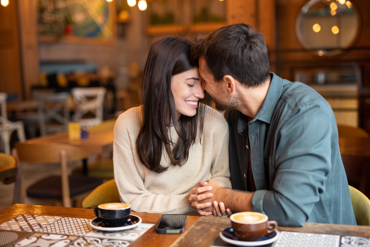 Smiling couple holding hands at a cafe