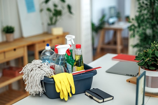 Bucket of cleaning supplies sitting on the counter.