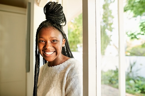 Cheerful teen sitting by the window.